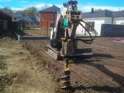 Excavatrice creusant le sol pour des travaux de fondation sur un chantier