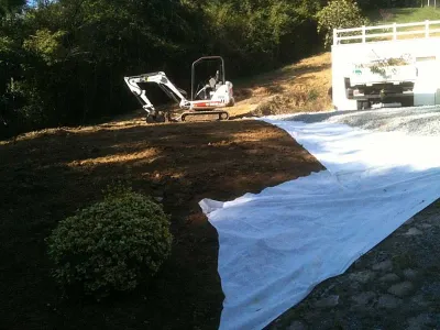 Terrassement et pose de géotextile pour stabilisation du sol avant aménagement extérieur