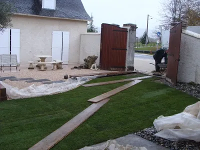 Engazonnement en cours avec cheminement bois pour aménagement de patio