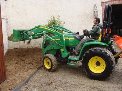 Travaux de terrassement du patio avec engin agricole pour mise à niveau du sol