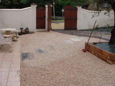 Patio en gravier clair avec bac bois et préparation des cheminements piétons