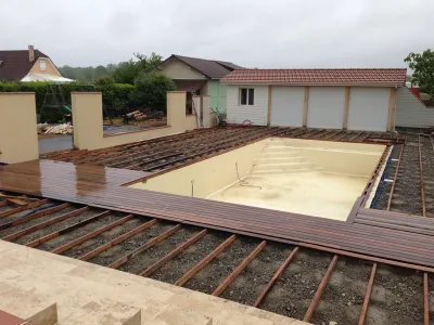Structure bois en cours de pose pour terrasse extérieure autour d’une piscine