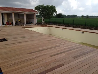 Terrasse bois finalisée autour d’une piscine, intégrée à un jardin paysager