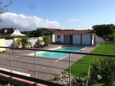 Jardin contemporain avec piscine, terrasse bois et pelouse soignée
