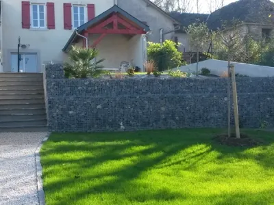 Jardin aménagé avec mur en gabions, escaliers extérieurs et pelouse soignée