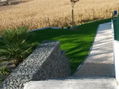 Mur de soutènement en gabions et cheminement piéton dans un jardin aménagé