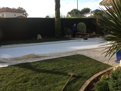 Pose d’un gazon en rouleaux autour d’une piscine lors d’une rénovation de jardin