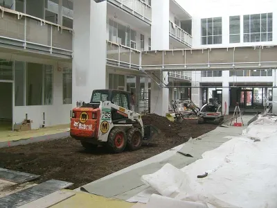 Travaux de préparation du sol pour création d’un jardin d’intérieur dans une école