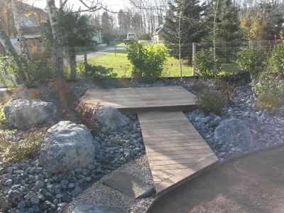 Passerelle bois et roches décoratives pour création d’un espace détente paysager