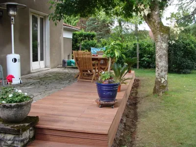 Vue latérale de l’extension de terrasse bois aménagée dans le jardin