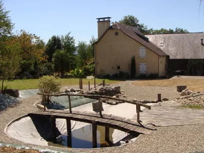 Bassin naturel avec passerelle bois et mise en eau partielle après rénovation