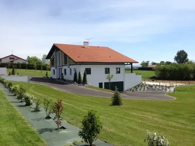Jardin aménagé avec pelouse soignée et allée végétalisée autour de la maison
