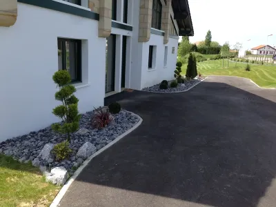 Allée en enrobé et massifs minéraux pour aménagement extérieur de maison moderne